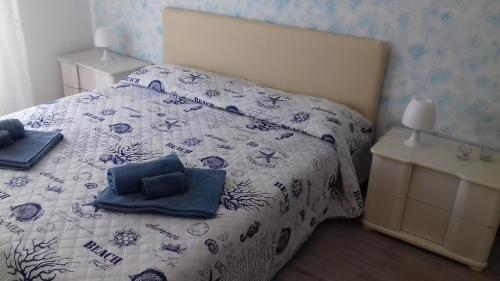 a bedroom with a bed with a blue and white comforter at Casarcobaleno in Trieste