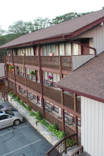 an apartment building with a car parked in a parking lot at Cliff Dwellers Inn in Blowing Rock