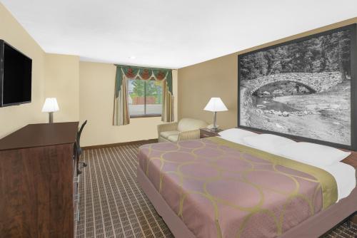 a hotel room with a bed and a flat screen tv at Super 8 by Wyndham Webster City IA in Webster City