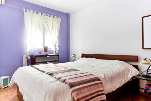 トレビエハにあるVilla Boubghilaのベッドルーム1室(紫の壁のベッド1台、窓付)