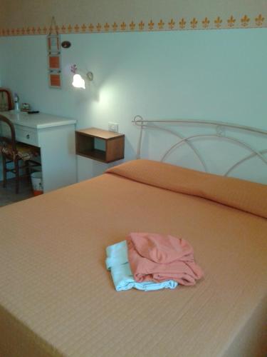 a pile of clothes sitting on top of a bed at B&B Monticelli in Gubbio