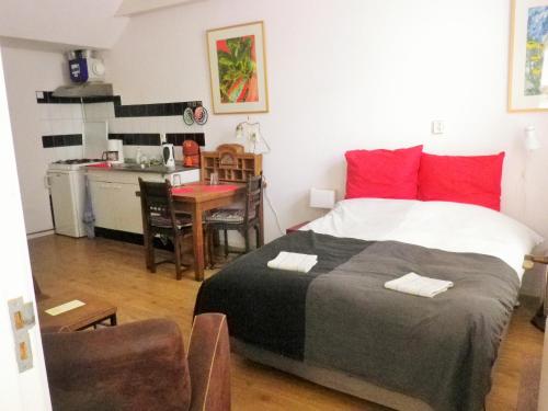 a bedroom with a large bed and a kitchen at Appartement centrum Groningen in Groningen