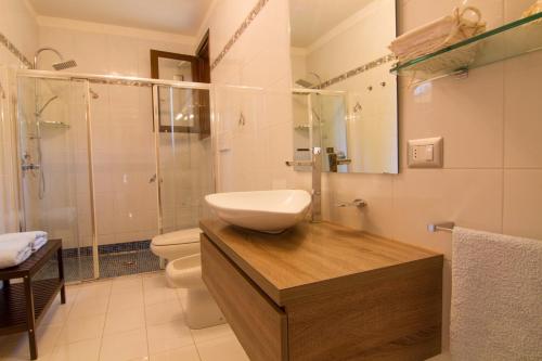 ein Bad mit einem Waschbecken, einem WC und einer Dusche in der Unterkunft B&B GARDA IN in Gardone Riviera