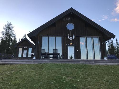 a large building with glass windows on top of a field at Ottsjö-Åre Lodge in Ottsjö
