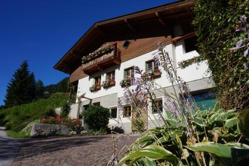a house in the mountains with flowers on the windows at Ferienwohnung am Sonnseitweg in Grossarl