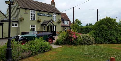an old car parked in front of a house at The White Horse Inn in Cambridge