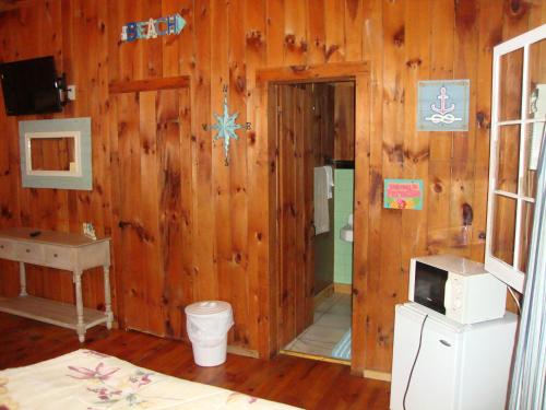 a room with a wooden wall with a toilet and a sink at Paradise Resort Saratoga in Gansevoort