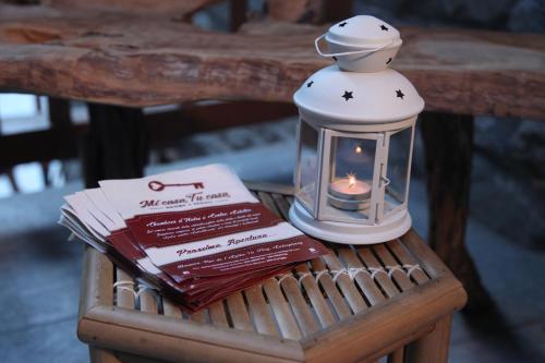 a candle in a glass lantern sitting on top of a table at Mi Casa Tu Casa in Brusson
