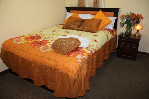 Un dormitorio con una cama con almohadas. en Hotel Residencial El Viajero en Tababela