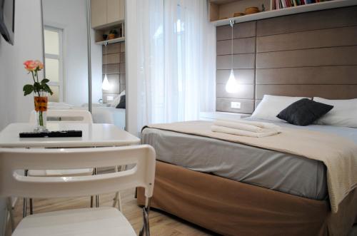 アテネにあるAthens Nestの小さなベッドルーム(ベッド1台、テーブル、椅子付)