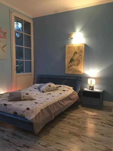 une chambre avec un lit, une lampe et une fenêtre dans l'établissement Le Chant Des Oiseaux, à Magny-les-Hameaux