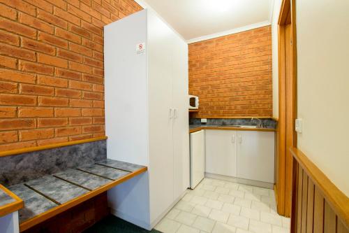 a kitchen with a sink and a bench at Golden River Motor Inn in Moama