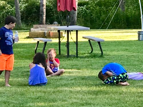 a group of children sitting in the grass at Cedar Ridge Cabins in Honor