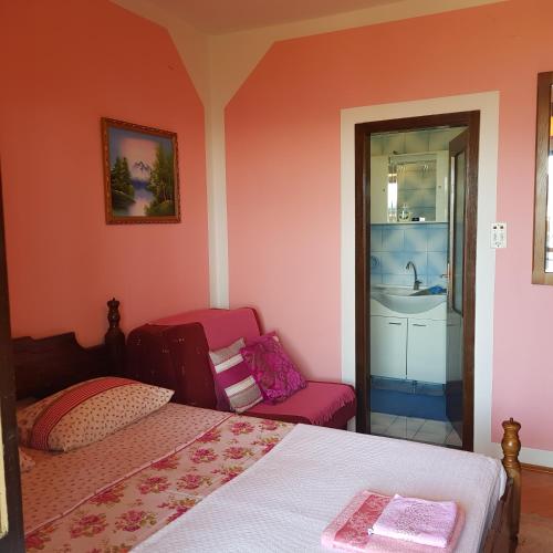 a bedroom with a bed and a chair and a sink at Guest House Cinderella in Herceg-Novi