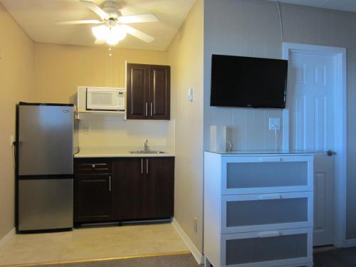 a kitchen with a black refrigerator and a microwave at Balm Beach Resort and Motel in Balm Beach