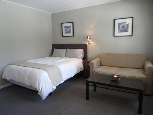 a bedroom with a bed and a couch and a table at Balm Beach Resort and Motel in Balm Beach