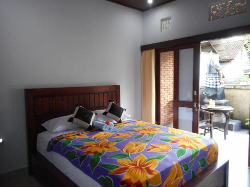 a bedroom with a bed with a colorful comforter at Pondok Indah Homestay in Sidemen