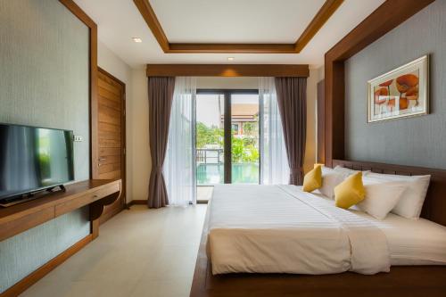 ein Schlafzimmer mit einem großen Bett und einem TV in der Unterkunft Villa Palavee (B3) in Ao Nang Beach