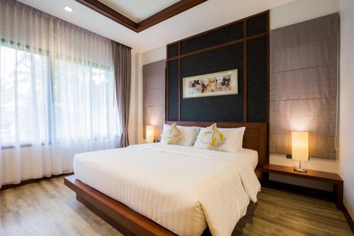 a bedroom with a large bed and a large window at Villa Raeya in Ao Nang Beach