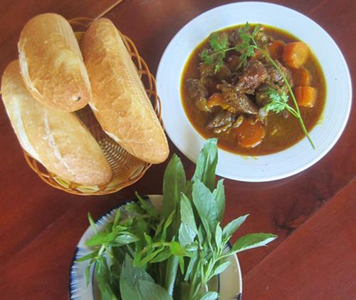 a table with a bowl of soup and a plate of bread at Gia Thanh Phu Quoc Guest House in Phu Quoc