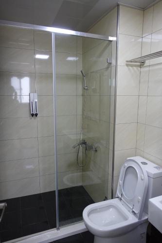 a bathroom with a shower with a toilet and a sink at Backpack Home 497 in Jinhu