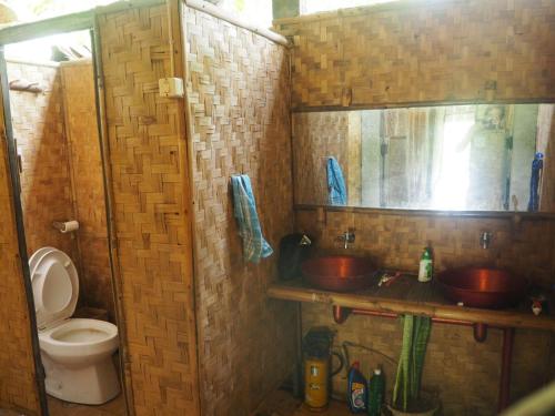 a bathroom with two sinks and a toilet at d'Jarwo House in Batukaras