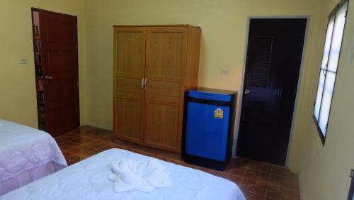a room with two beds and a blue refrigerator at Captan Home in Haad Chao Phao