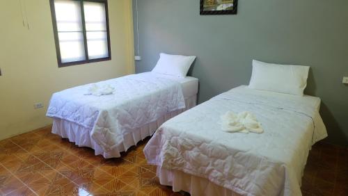 two beds in a room with towels on them at Captan Home in Haad Chao Phao