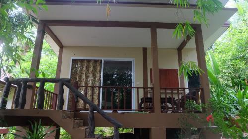 a house with a balcony with a staircase at Captan Home in Haad Chao Phao