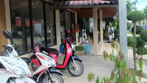 a group of motorcycles parked outside of a store at Captan Home in Haad Chao Phao