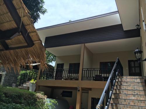 a house with a staircase and a balcony at Captan Home in Haad Chao Phao
