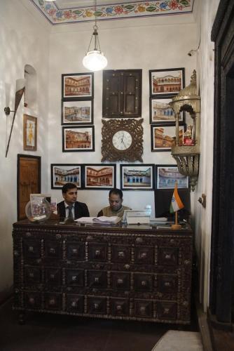 two men sitting at a desk in a room at Haveli Dharampura & Golden Haveli- UNESCO awarded Boutique Heritage Hotel in New Delhi
