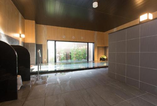 a bathroom with a swimming pool in a building at Hotel Route-Inn Higashiomi Yokaichi Ekimae in Yōkaichi