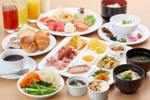 stół z talerzami jedzenia i napojów w obiekcie Hotel Yugaf Inn Okinawa w mieście Nago