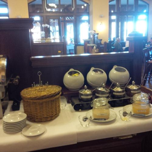 a table with plates and jars and a basket on it at Berg-Gasthof Honigbrunnen in Löbau