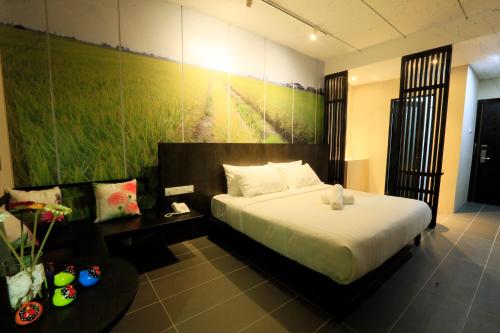1 dormitorio con 1 cama y una pintura en la pared en Vi Boutique Hotel, en Kuala Selangor