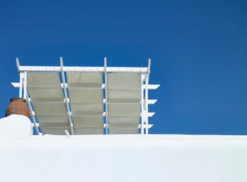 a ladder on top of a building with a blue sky at Folegandros Apartments in Chora Folegandros