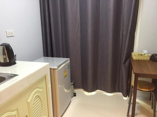 uma cozinha com um lavatório e uma cortina de chuveiro em A-Place Suvarnabhumi em Lat Krabang