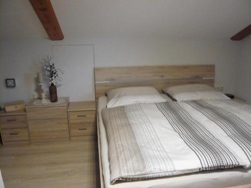 een slaapkamer met een houten bed en een houten dressoir bij Gastehaus Helga in Bodenmais