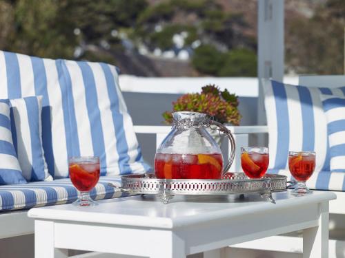 a tray with a pitcher and two wine glasses on a table at Folegandros Apartments in Chora Folegandros