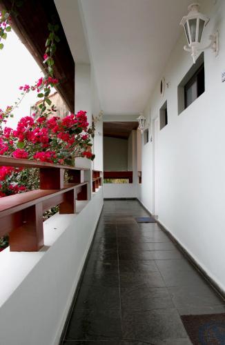 a corridor of a building with pink flowers at Pousada Larimor in Boicucanga