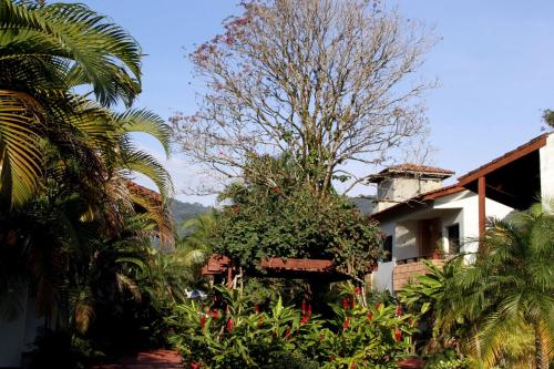 a house with a tree in front of it at Pousada Larimor in Boicucanga