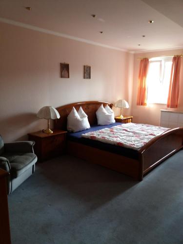 a bedroom with a bed and a chair and a window at Haus Forstamt in Stadtsteinach