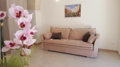 a couch in a living room with pink flowers at ALIMAR B&B in Lizzano
