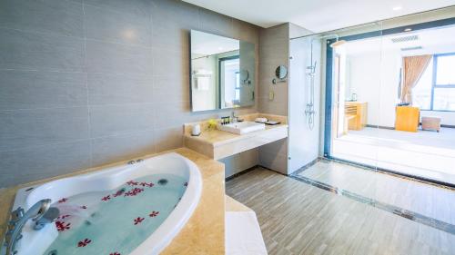 a bathroom with a tub and a sink at Muong Thanh Luxury Da Nang Hotel in Da Nang