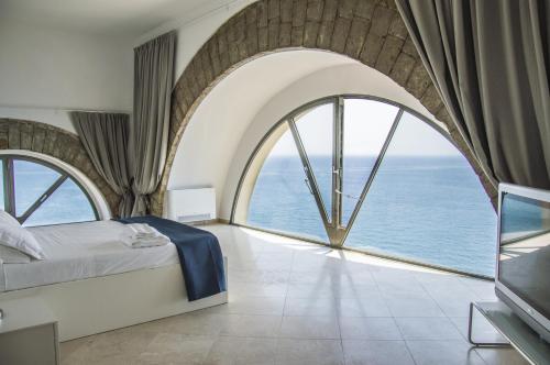 a bedroom with a large window with a bed and a television at Sunrise Guest House in Gaeta