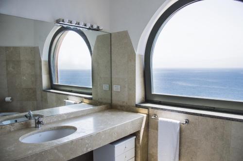 a bathroom with a sink and an arch window at Sunrise Guest House in Gaeta