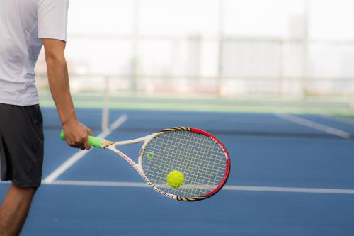 a man holding a tennis racket and a tennis ball at Muong Thanh Luxury Da Nang Hotel in Da Nang