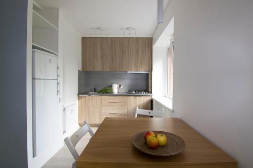 een keuken met een houten tafel met een fruitschaal erop bij Blue city apartment in Klaipėda