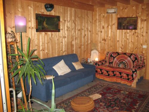 a living room with a blue couch and a chair at BioAgriturismo Vegan Campo di Cielo in Cesiomaggiore